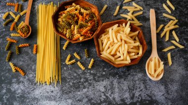 Çeşitli makarna çeşitleri, çiğ makarna seti ve domates seti. Yakın çekim.