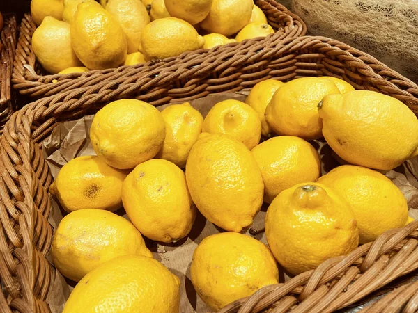 Fresh yellow lemon on shelf in vegetables and fruits area at Hypermarket, healthy concept. Lemon in basket