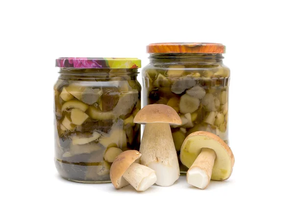 Fresh mushrooms and jars of pickled mushrooms — Stock Photo, Image