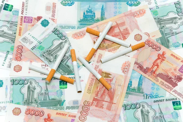 Cigarettes and rubles. Expensive habits. — Stock Photo, Image