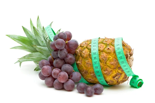 Pineapple, grapes and measuring tape — Stock Photo, Image