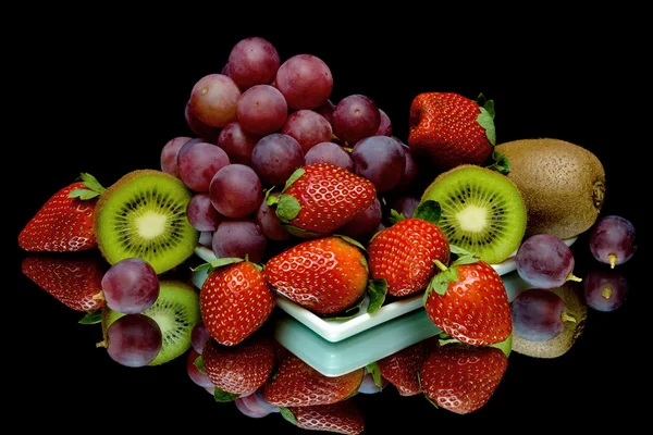 Uvas, kiwi y fresas sobre fondo negro — Foto de Stock