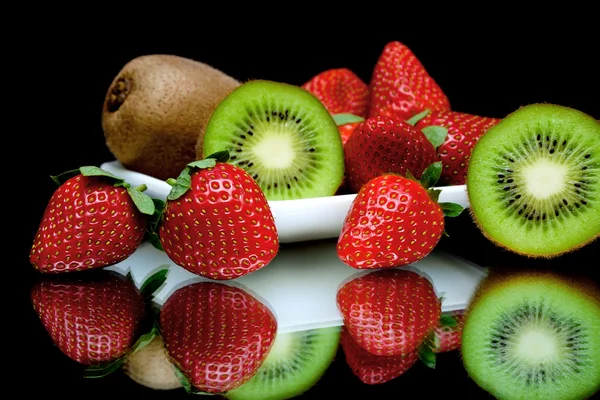 Kiwi dan strawberry pada penutupan latar belakang hitam — Stok Foto