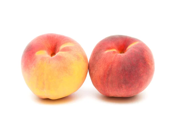 Два персика на белом фоне крупным планом — стоковое фото