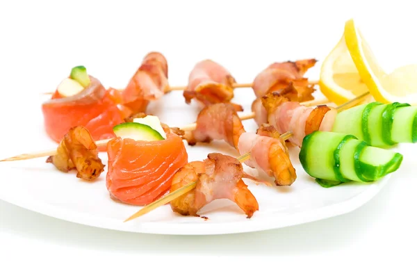 Rolls of salmon and shrimp with bacon on a plate — Stock Photo, Image