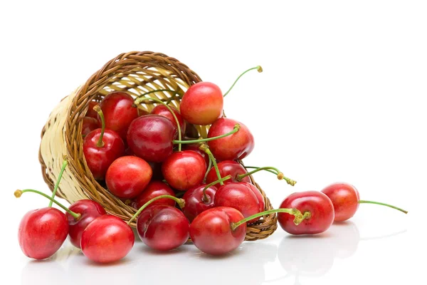 Ripe cherry in a wicker basket on a white background close-up. — Stock Photo, Image