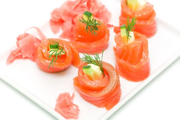 Rotoli di salmone con formaggio e cetriolo su sfondo bianco — Foto Stock