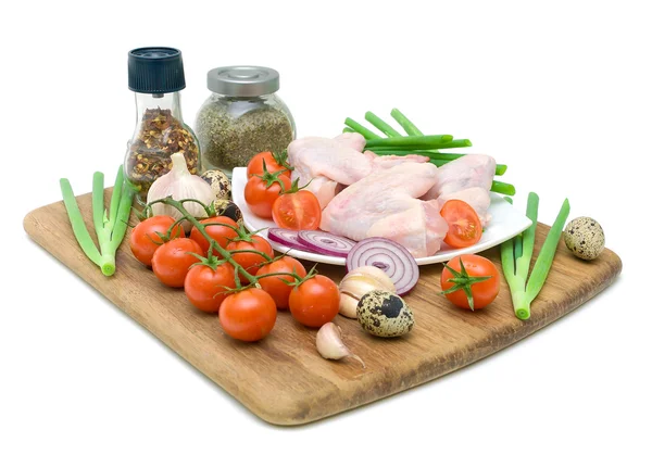 Färska grönsaker, vaktelägg och rå kycklingvingar isolerad på w — Stockfoto