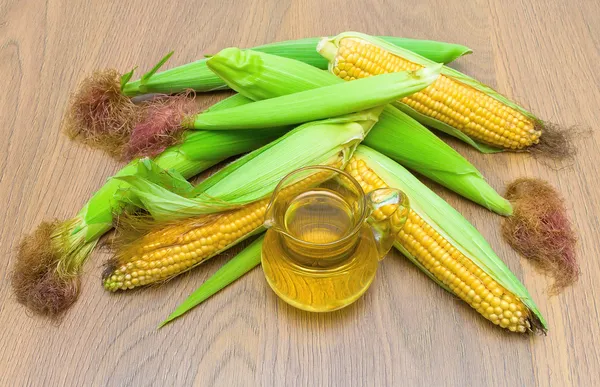 Espigas de maíz y aceite. vista superior - foto horizontal . — Foto de Stock