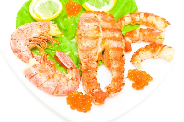 Trucha de carne frita con limón y ensalada, camarones, caviar rojo en un — Foto de Stock