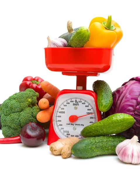 Básculas de cocina y verduras frescas maduras sobre fondo blanco — Foto de Stock