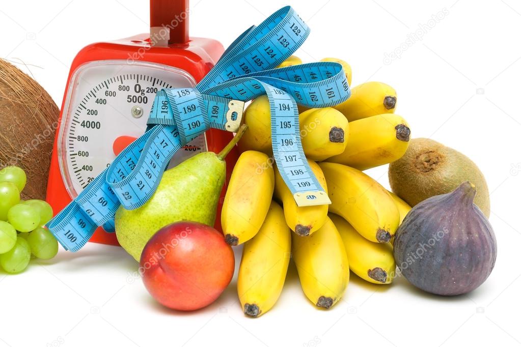 Fruit, kitchen scales and measuring tape close up. white backgro Stock
