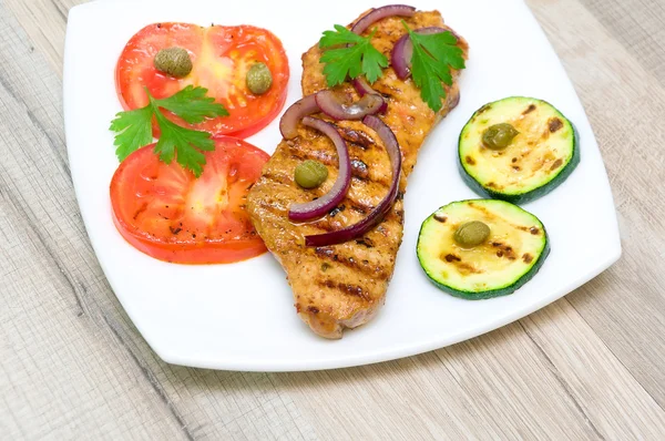 Carne assada com legumes em um prato branco — Fotografia de Stock