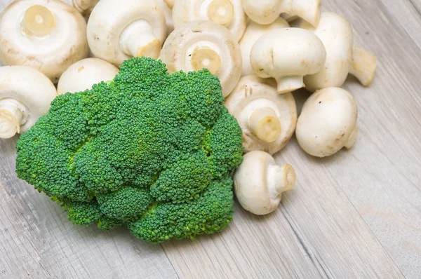 Broccoli e funghi da vicino su tavola di legno — Foto Stock