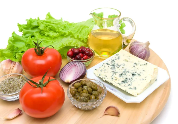 Vegetables, cranberries, cheese and sunflower oil on a cutting b — Stockfoto