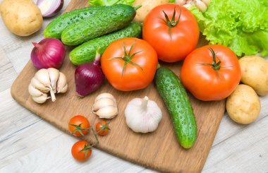 kesme tahtası ahşap bir masa üzerinde taze sebze