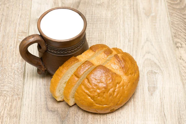 Pão e leite em uma caneca de barro close-up — Fotografia de Stock