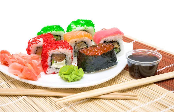 Sushi met rode kaviaar en rollen close-up op een witte plaat — Stockfoto