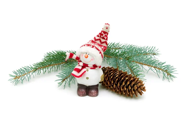 Toy snowman and fir-cone on a branch isolated on a white backgro Stock Picture
