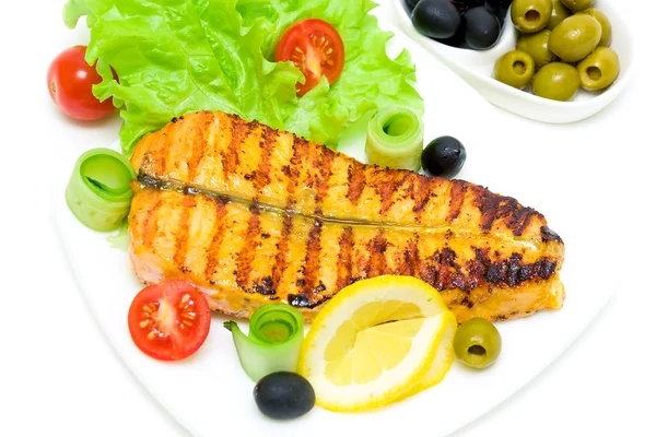Un trozo de pescado a la parrilla con verduras en el plato en un blanco — Foto de Stock