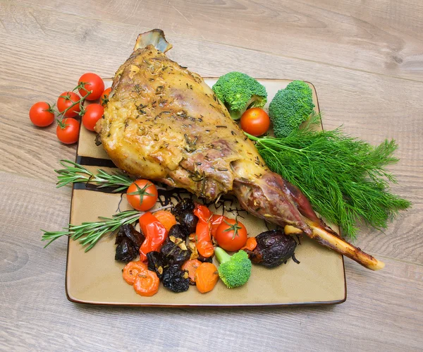 Roasted leg of lamb with vegetables, greens and prunes — Stock Photo, Image