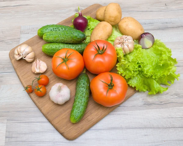 Zelenina na prkénko na dřevěný stůl closeup — Stock fotografie