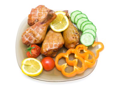 smoked chicken legs with vegetables and lemon on white backgroun clipart