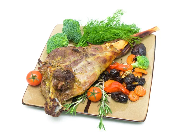 Roasted leg of lamb with vegetables and greens on a white backgr — Stock Photo, Image