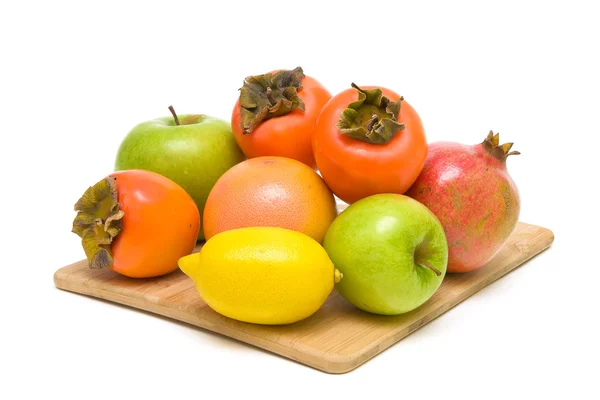 Fruit on a wooden cutting board on white background — Stock Photo, Image