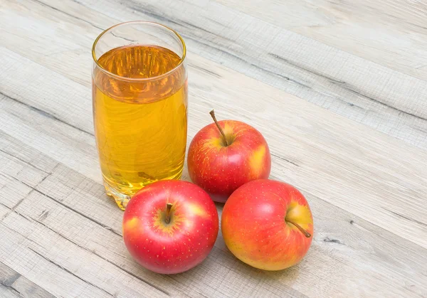 Um copo de suco e maçãs vermelhas closeup — Fotografia de Stock