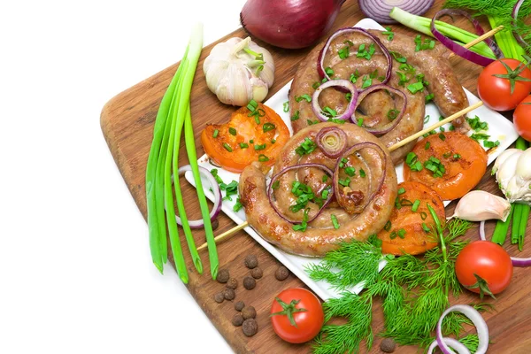 Grilled sausages and vegetables on a cutting board on a white ba — Stock Photo, Image