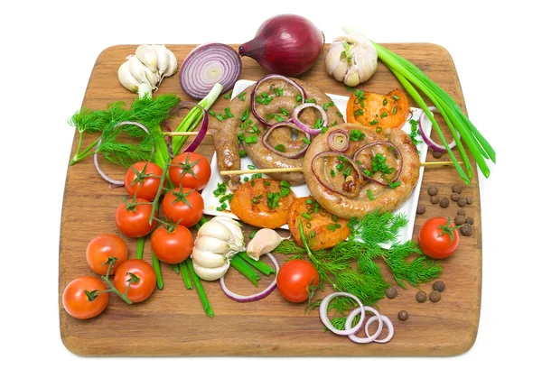 Salsichas grelhadas com legumes na tábua de corte em backg branco — Fotografia de Stock