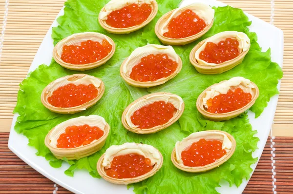 Tartaletas con caviar rojo y mantequilla en un plato — Foto de Stock