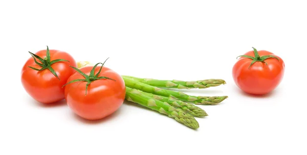 Rijpe tomaten en asperges geïsoleerd op witte achtergrond — Stockfoto