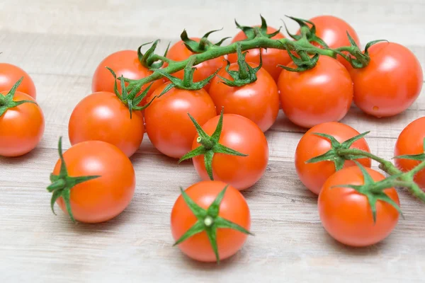 Wiśniowe pomidory na drewniane tło zbliżenie — Zdjęcie stockowe