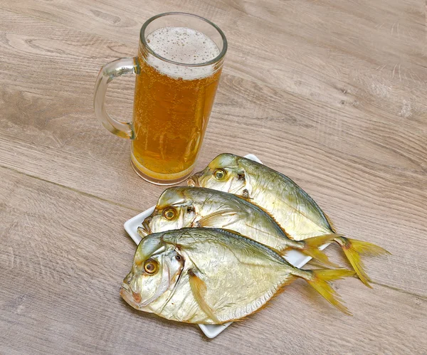 Fumado Vômer e copo de cerveja lager em uma mesa de madeira — Fotografia de Stock