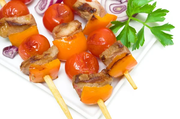 Kebab con carne y verduras en un plato blanco sobre un respaldo blanco —  Fotos de Stock