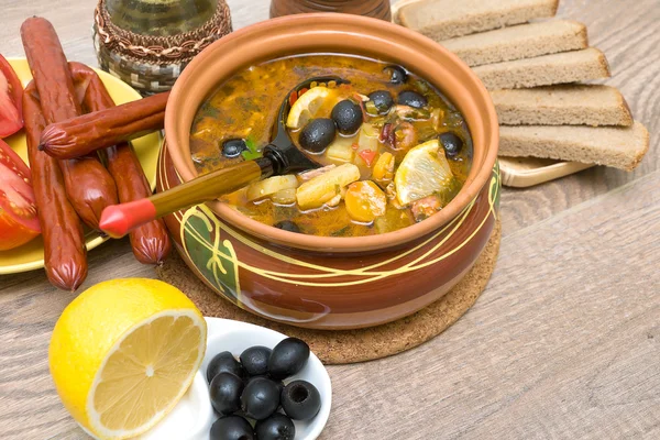 Dish of russian hodgepodge soup in ceramic pot. — Stock Photo, Image