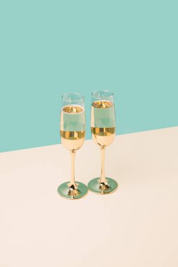İki tonlu renkli arka planda şampanya kadehleri kutluyoruz. Yeni yıl kutlamaları minimum konsept