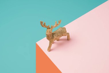 Geometrik renkli bir arka planda Noel ağacı geyiği süsü. En az kış tatili konsepti