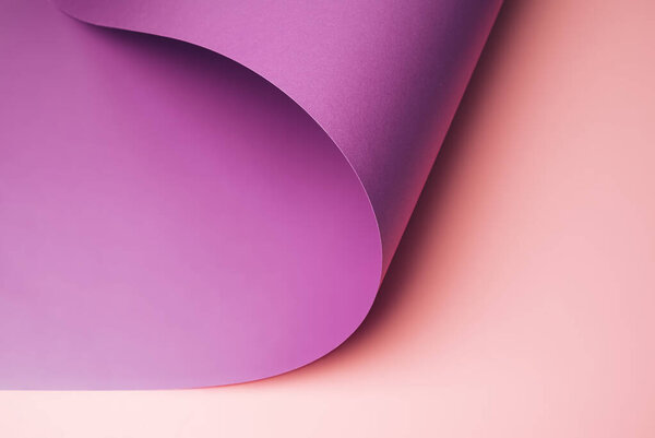 Lavender colored paper turned to expose pastel pink surface bellow. Minimal violet background