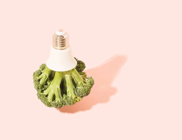 Brokoli Dengan Tutup Bola Lampu Pada Latar Belakang Merah Muda — Stok Foto