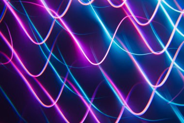 Karanlık bir gece geçmişinde neon mavi ve pembe çizgiler. Kaleydoskop fütürist arkaplan.