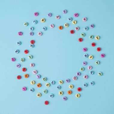 Kiril alfabesiyle yazılmış renkli düğmeler, pastel mavi arka planda daire çiziyor. Rusya ve Doğu Avrupa kavramsal zemin.