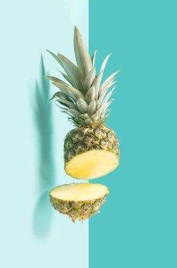 Pastel mavi arka planda havada yarıya bölünmüş taze ananas. Yaz meyveleri minimum arkaplan.