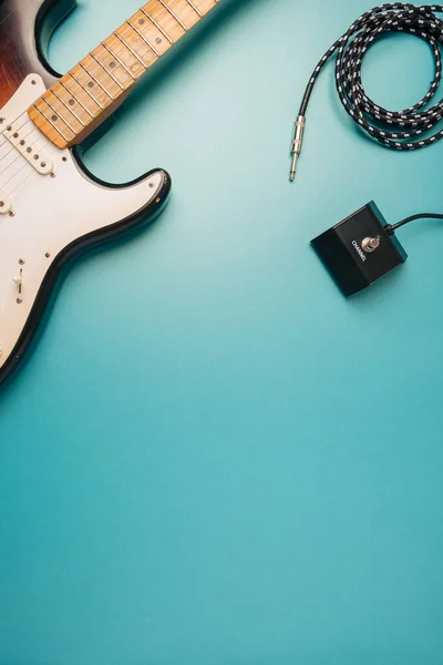 Rock, blues guitar and equipment on a teal background. Music, creativity backdrop.