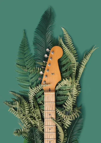 Worn electric guitar maple neck with foliage background. Nature sounds concept.