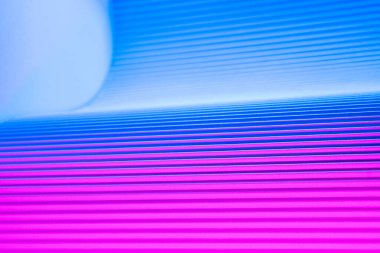 Neon hues over corrugated magenta and blue background. Futuristic abstract backdrop