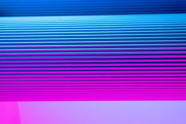 Neon hues over corrugated magenta and blue background. Futuristic abstract backdrop