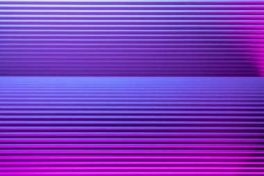 Violet and pink illuminated corrugated shapes. Geometric abstract background.